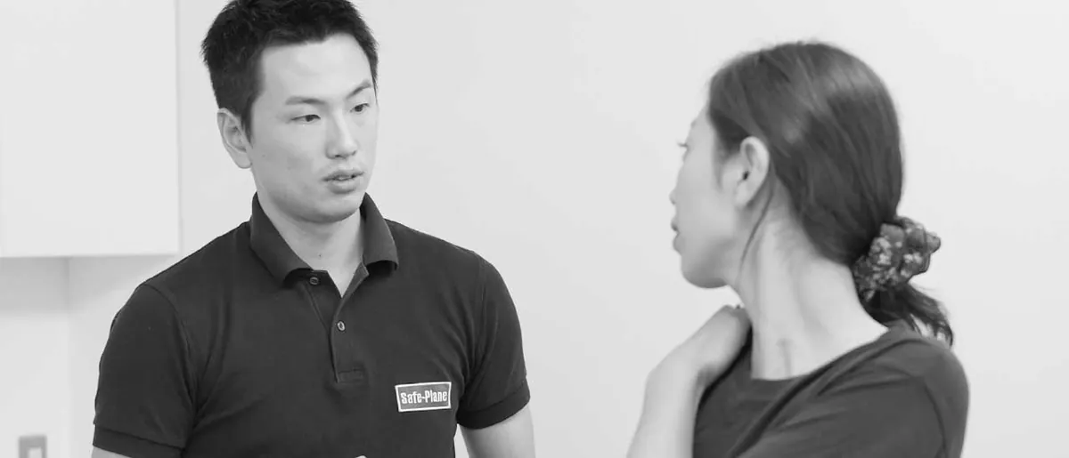 肩の不調を相談する女性と話を聞くトレーナー